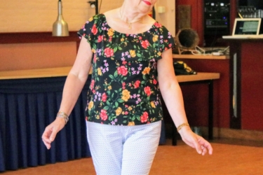 Vrouw met bloemtjes shirt die linedans aan het dansen is