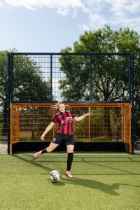 Bente staat klaar om de voetbal met haar rechterbeen weg te schoppen