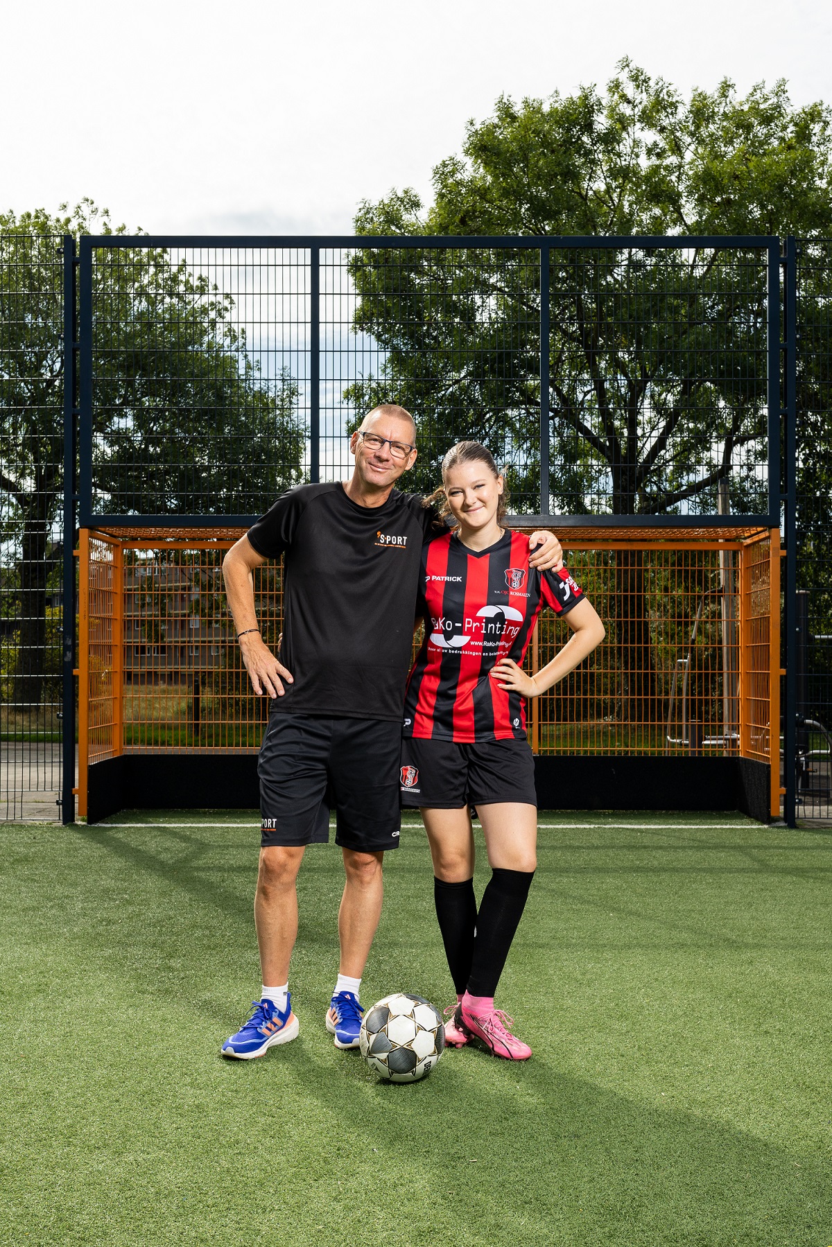 Bente (rechts) samen met haar vader; voor hen ligt een bal, achter hen staat een doel