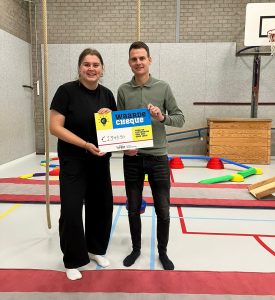 Full Force Dance Company uit Nuland ontvangt een stimuleringscheque voor peuter- en kleutergym in gymzaal Nuland; op achtergrond spelmaterialen