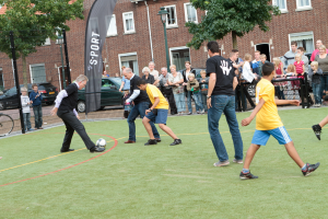 Mensen van alle leeftijden voetballen op Cruijff Court