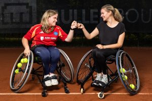 Floor (18) en Floor (19) geven elkaar een boks in hun rolstoelen op tennisbaan
