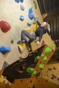 Janne lachend in actie tijdens het boulderen