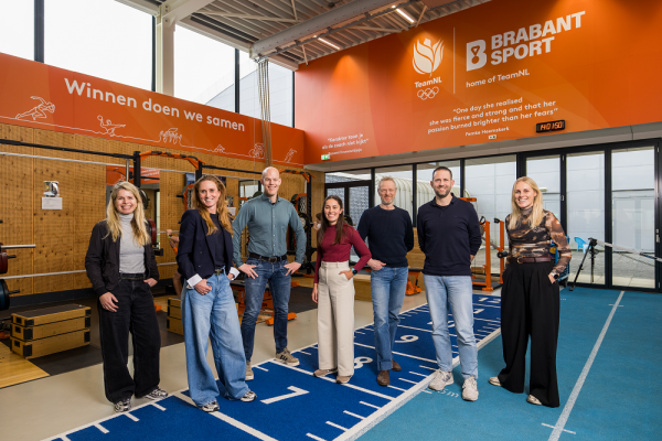 Drie mannen en vier vrouwen in een sportieve zaal met de logo's van Brabant Sport en Team NL duidelijk in beeld