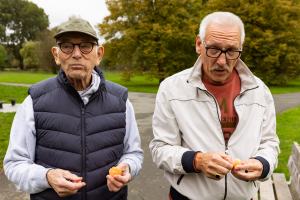Martin en zijn wandelmaatje eten een mandarijn tijdens wandelen