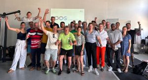 Groep enthousiaste Bossche ondernemers; achter hen op scherm staat 'POS': Platform Ondernemende Sportaanbieders