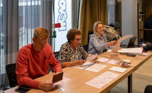 Drie vrijwilligers naast elkaar controleren de stemmen