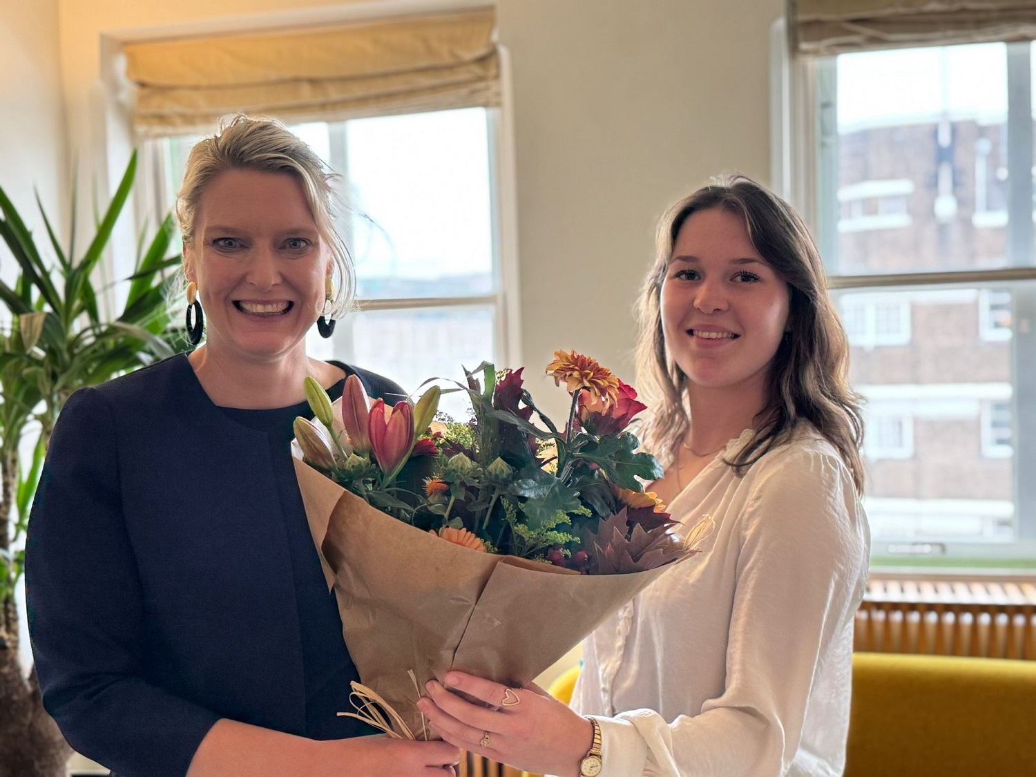 Fenna Vrehen (rechts) ontvangt een bloemetje van wethouder Marianne van der Sloot