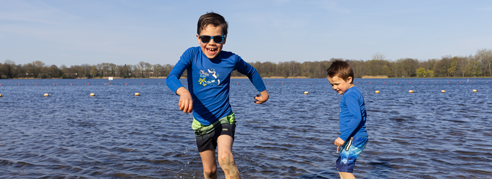 Twee jongens beleven waterpret bij een zwemplas