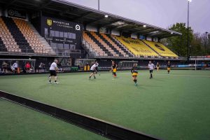 Senioren spelen puck naar elkaar over op hockeyveld